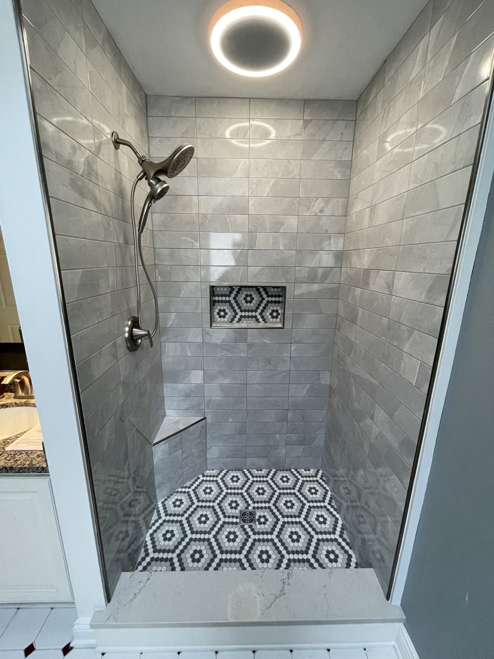 Finished tile shower with patterned tile floor